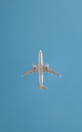 An airplane soars in the blue sky.