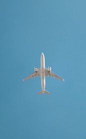 An airplane soars in the blue sky.