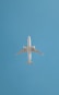 An airplane soars in the blue sky.