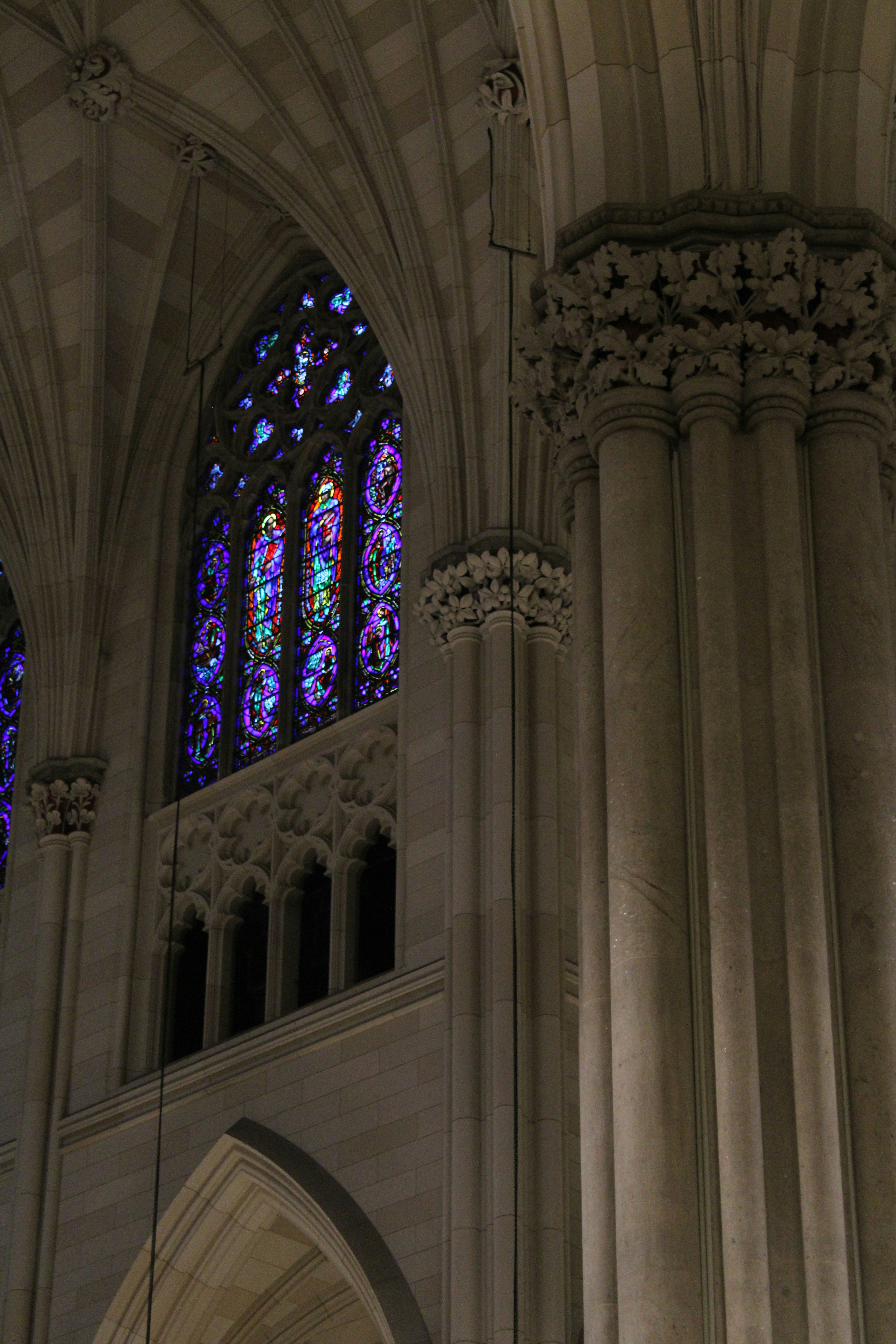 Stained glass illuminates a cathedral's interior.
