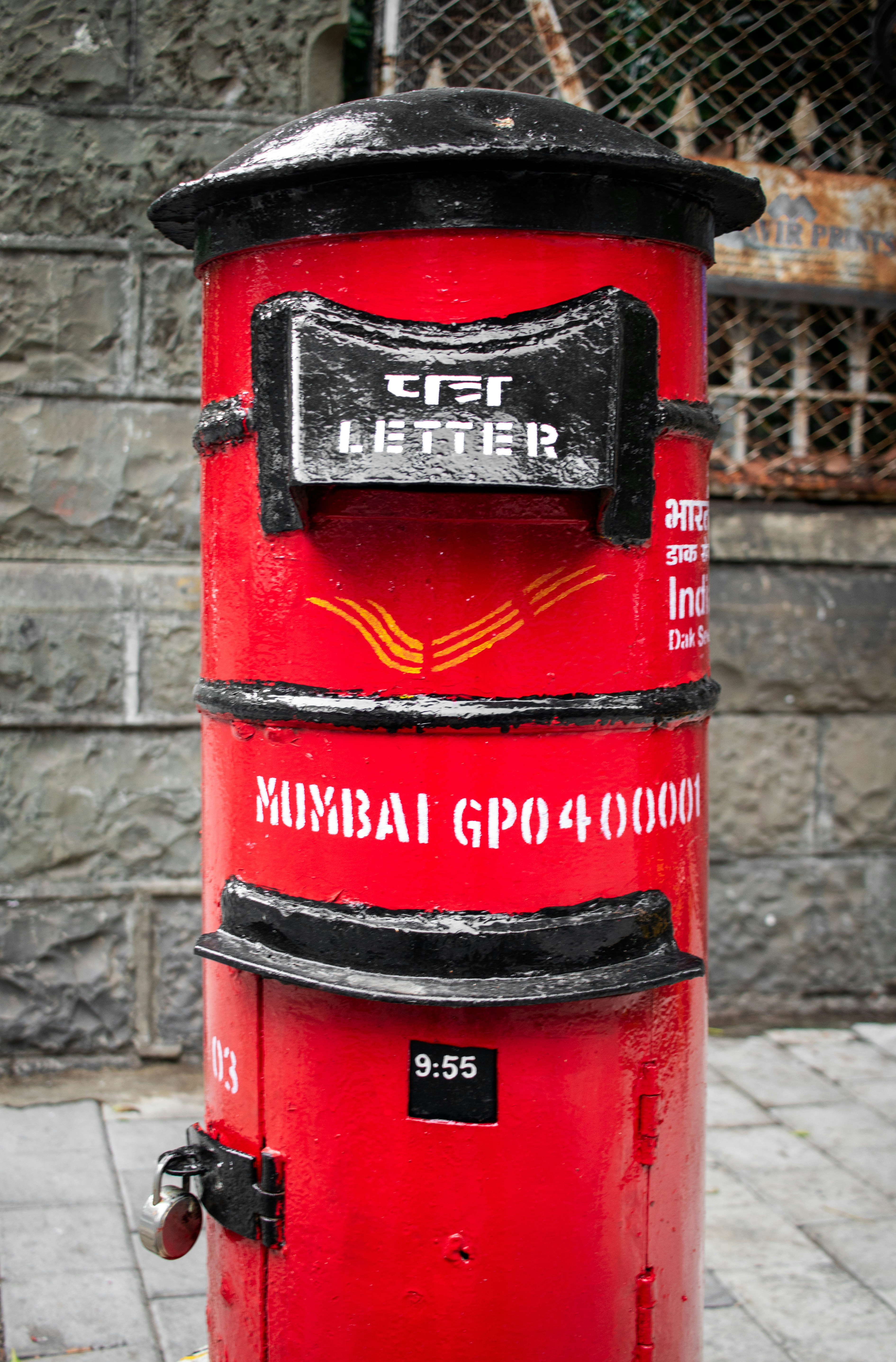 A red indian mailbox stands on a street.