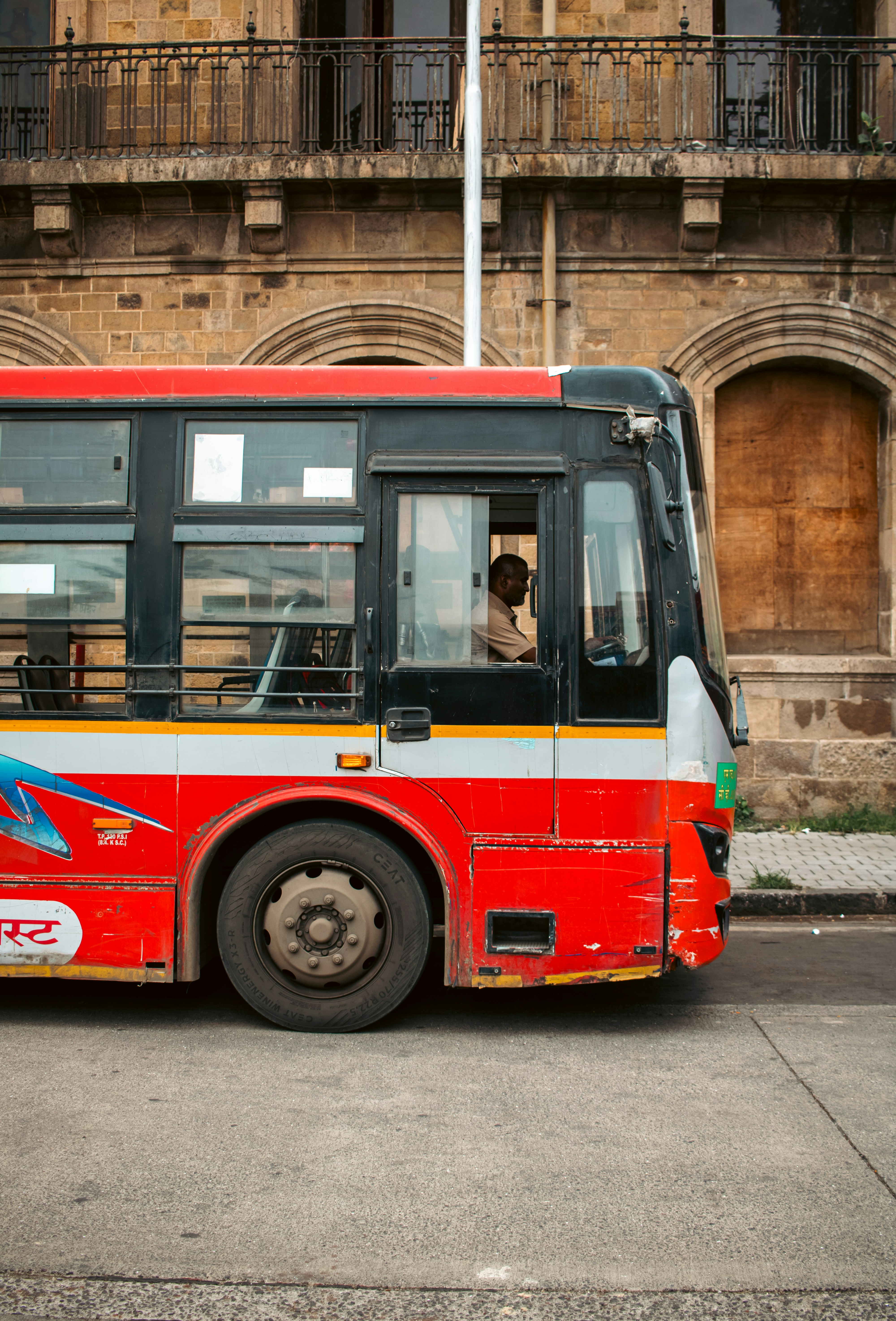 A red bus is parked in front of a building.