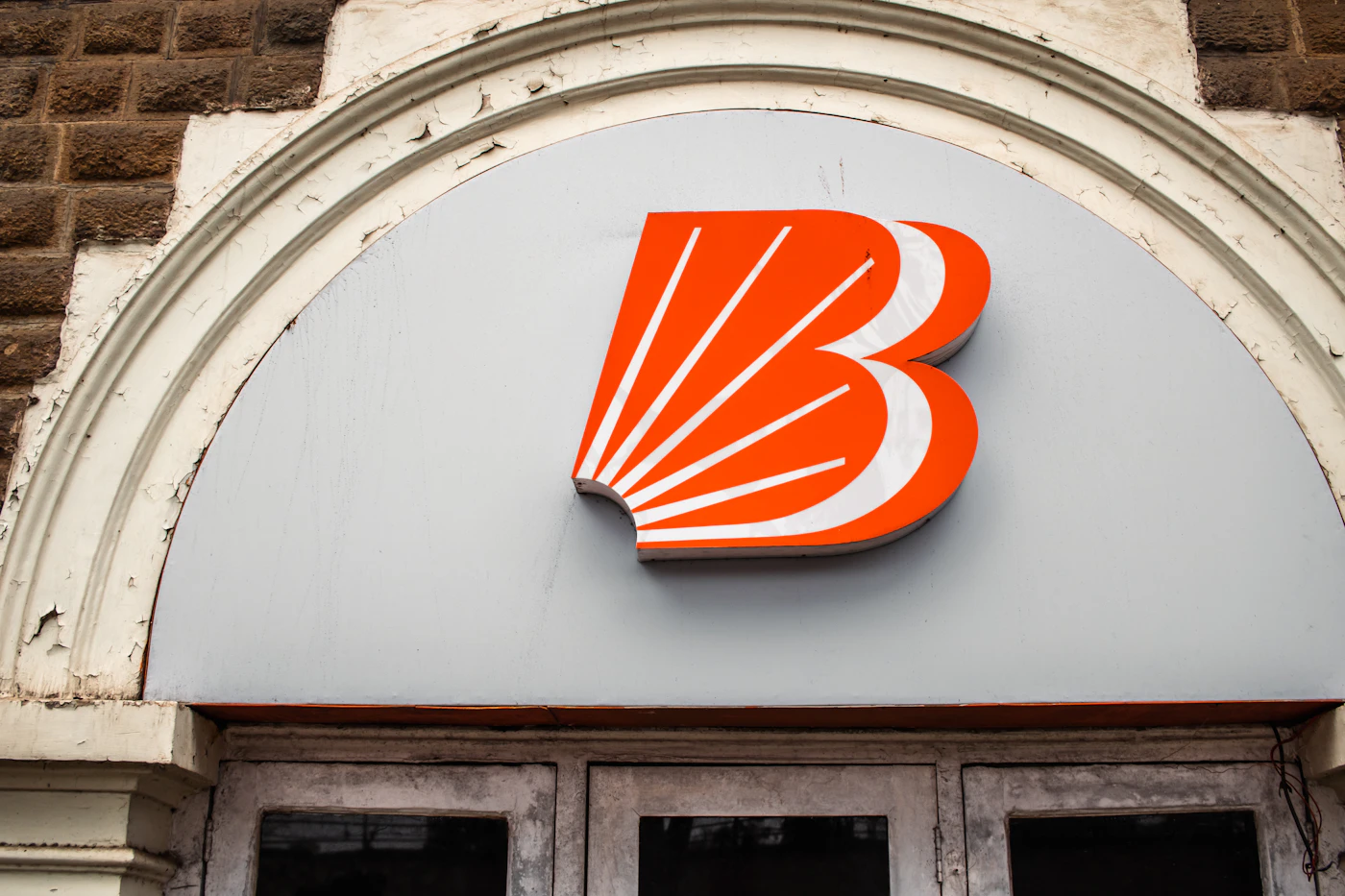 Orange bank branch sign on a stone building facade