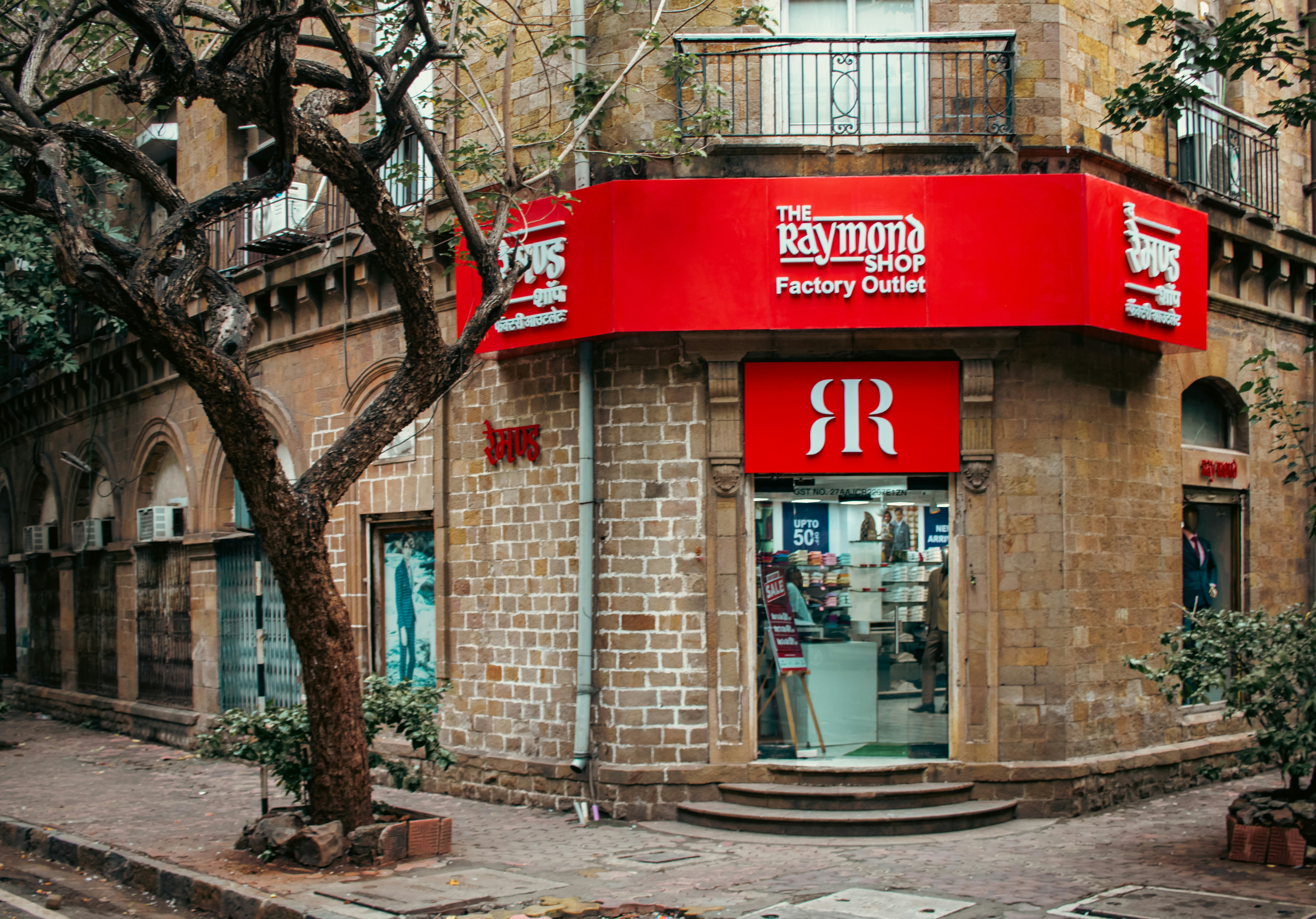 The Raymond Store in Ballard Estate, Mumbai, occupies a stately corner within this historic colonial business district. Known for its fine suiting and textile legacy, Raymond represents one of India’s most iconic menswear brands. The store's signage and display blend seamlessly with the neoclassical architecture of Ballard Estate, reflecting both brand heritage and urban sophistication.