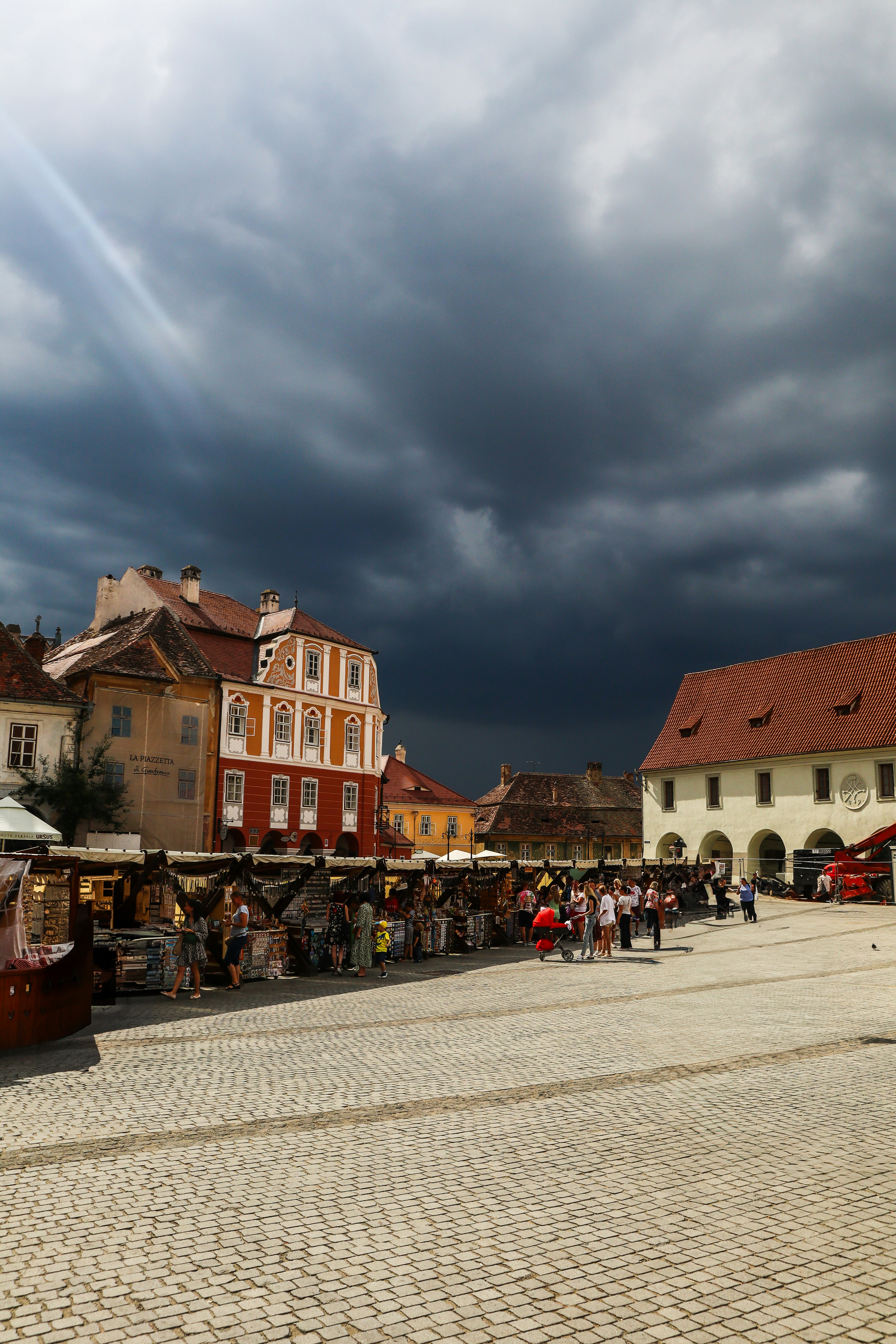 A square scene underneath a dark, stormy sky.