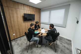 Three people are meeting in a conference room.