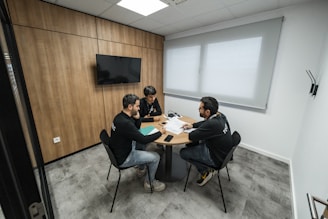 Three people are meeting in a conference room.