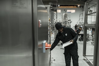A man inspects equipment in a modern factory.