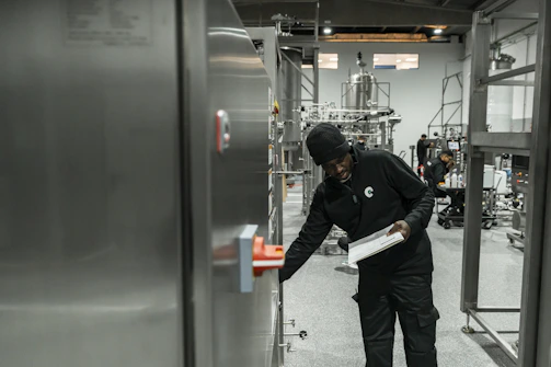 A man inspects equipment in a modern factory.