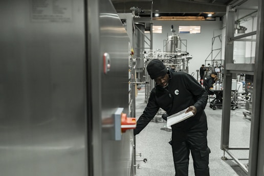 A man inspects equipment in a modern factory.