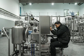 A man works on industrial machinery.