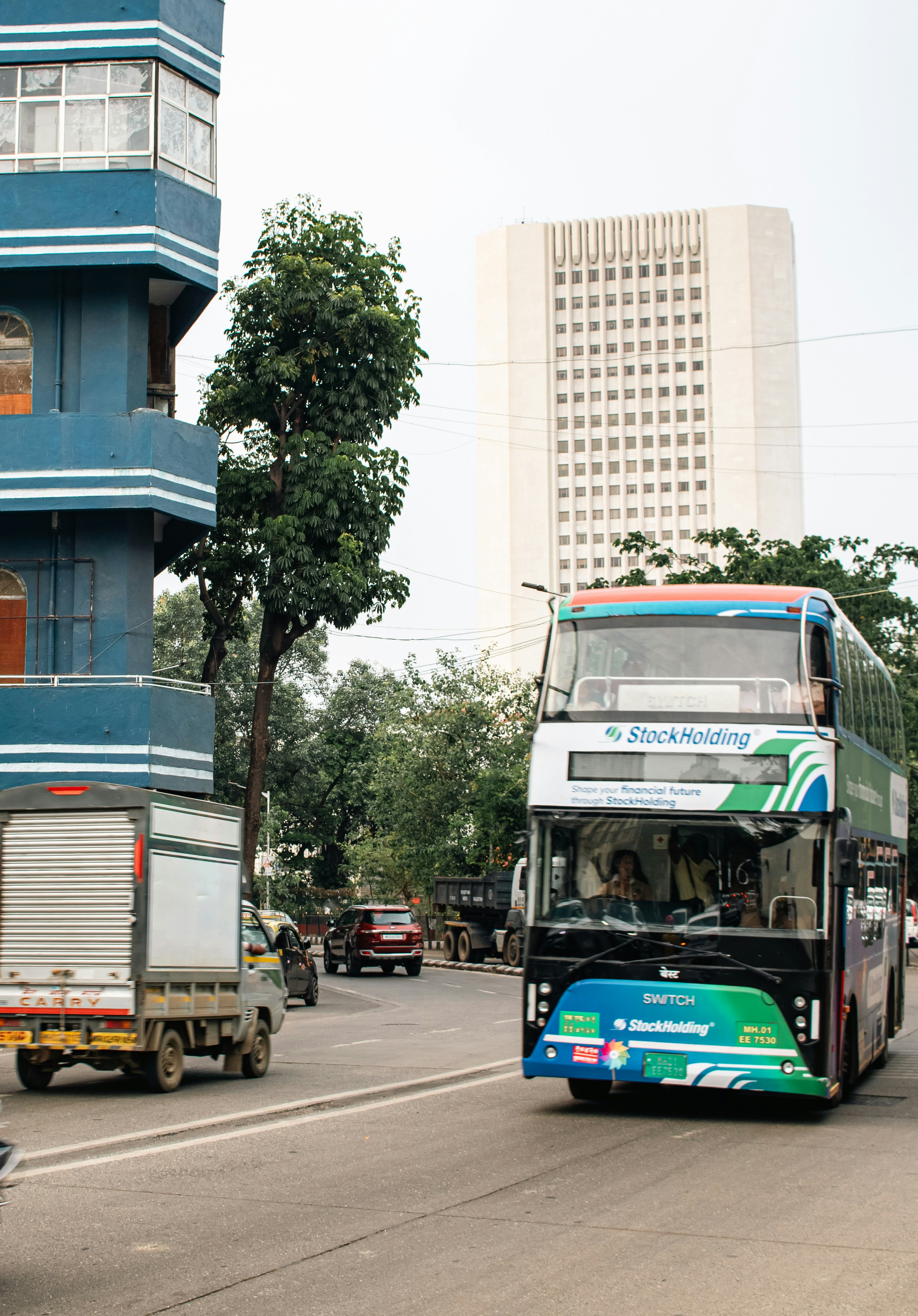 A double-decker bus travels down a busy street.