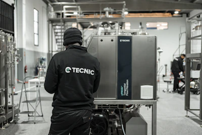 Worker looking at industrial machinery in a factory