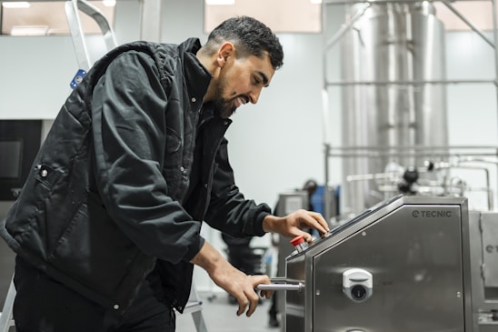 A man operates equipment in an industrial setting.