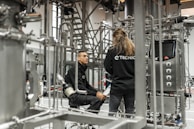 Two technicians discuss factory equipment.