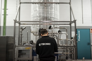 A worker inspects industrial equipment in a facility.