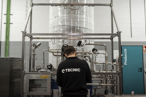 A worker inspects industrial equipment in a facility.