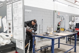 A worker is grinding metal in a workshop.