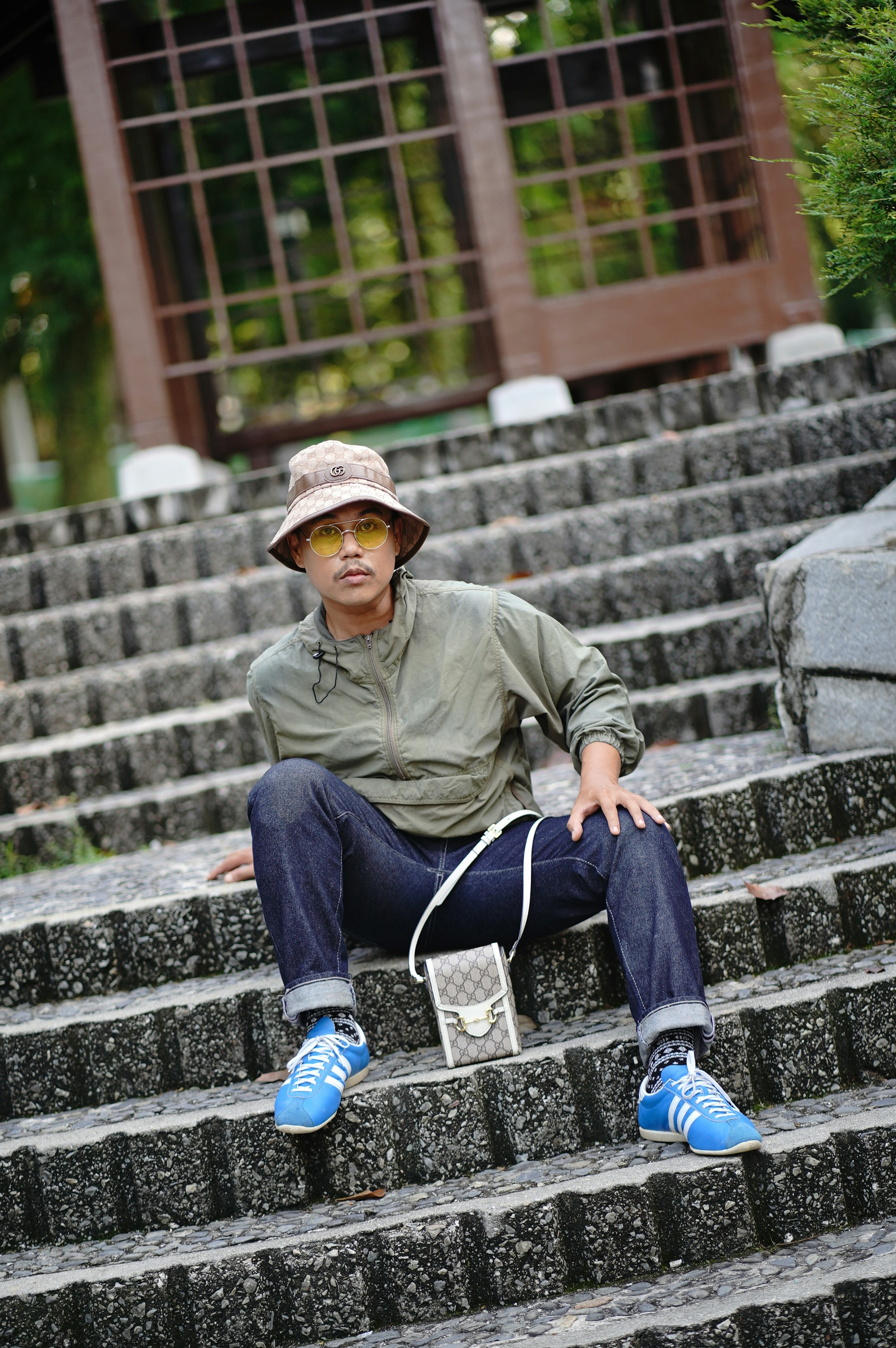 Stylish person sits on steps outdoors.