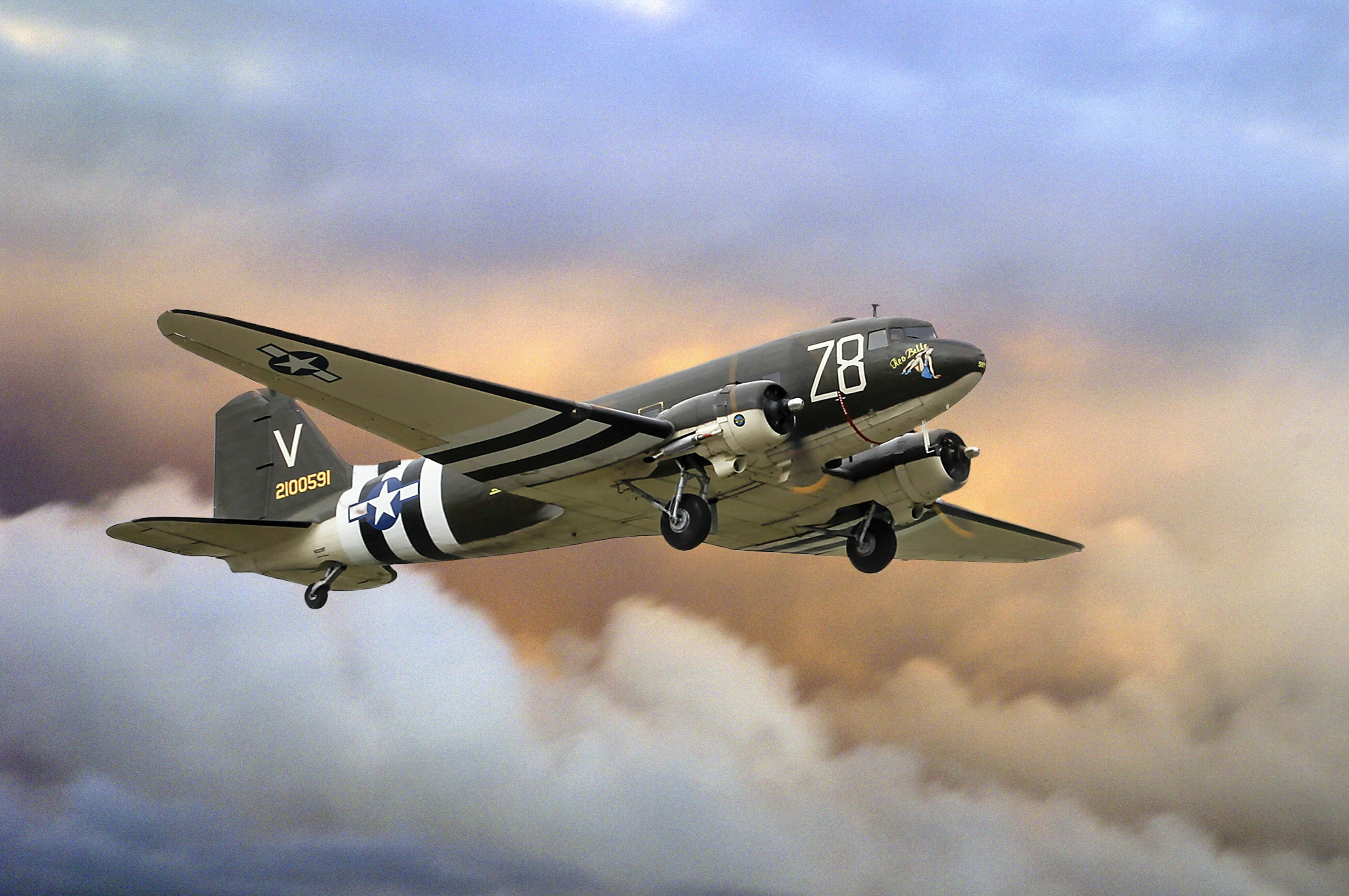 A vintage airplane flies amidst cloudy skies., WWII veteran C-47 Skytrain "Tico Belle" sporting invasion stripes flying high.