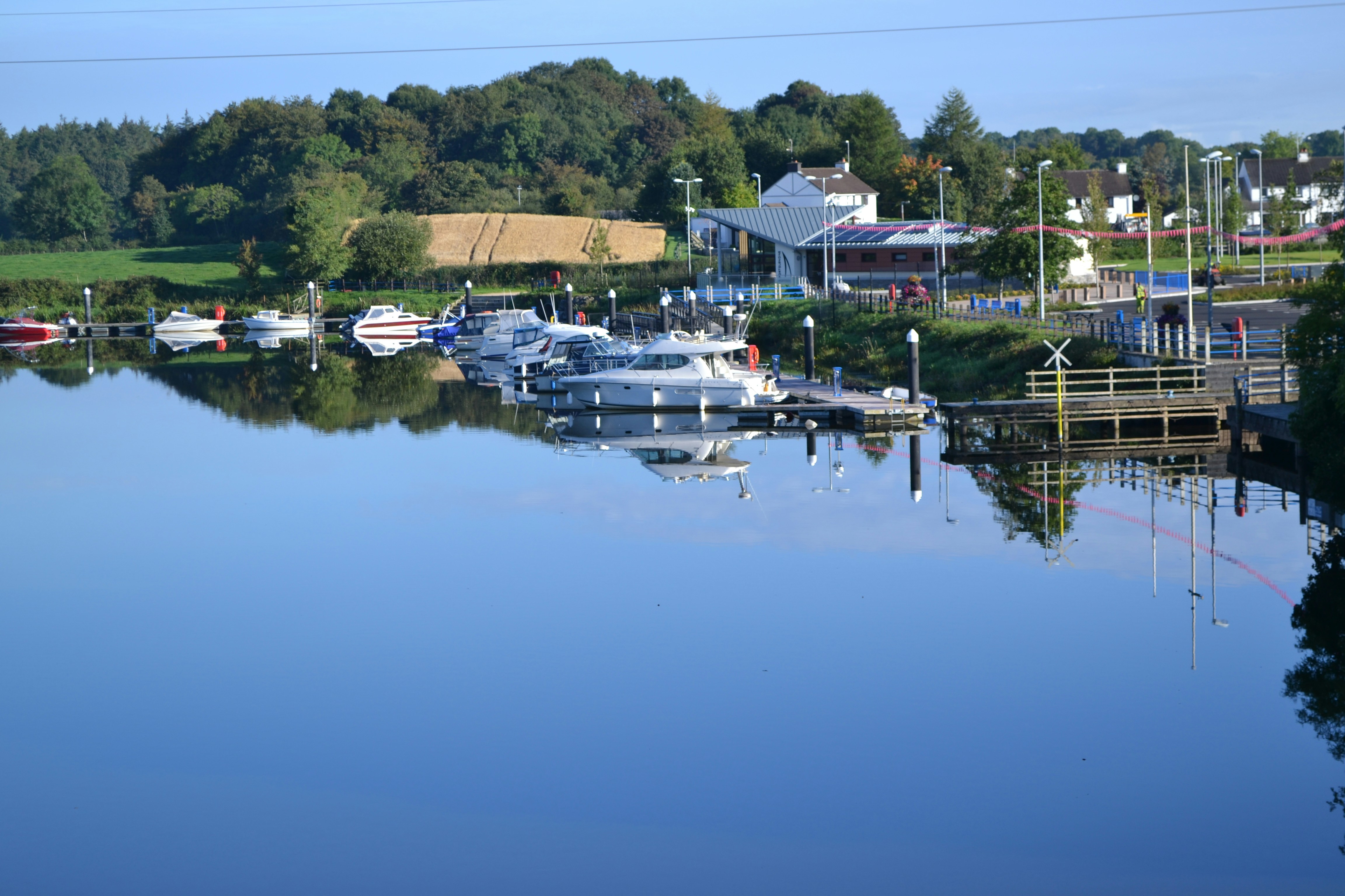 Boats are docked along a calm lake.