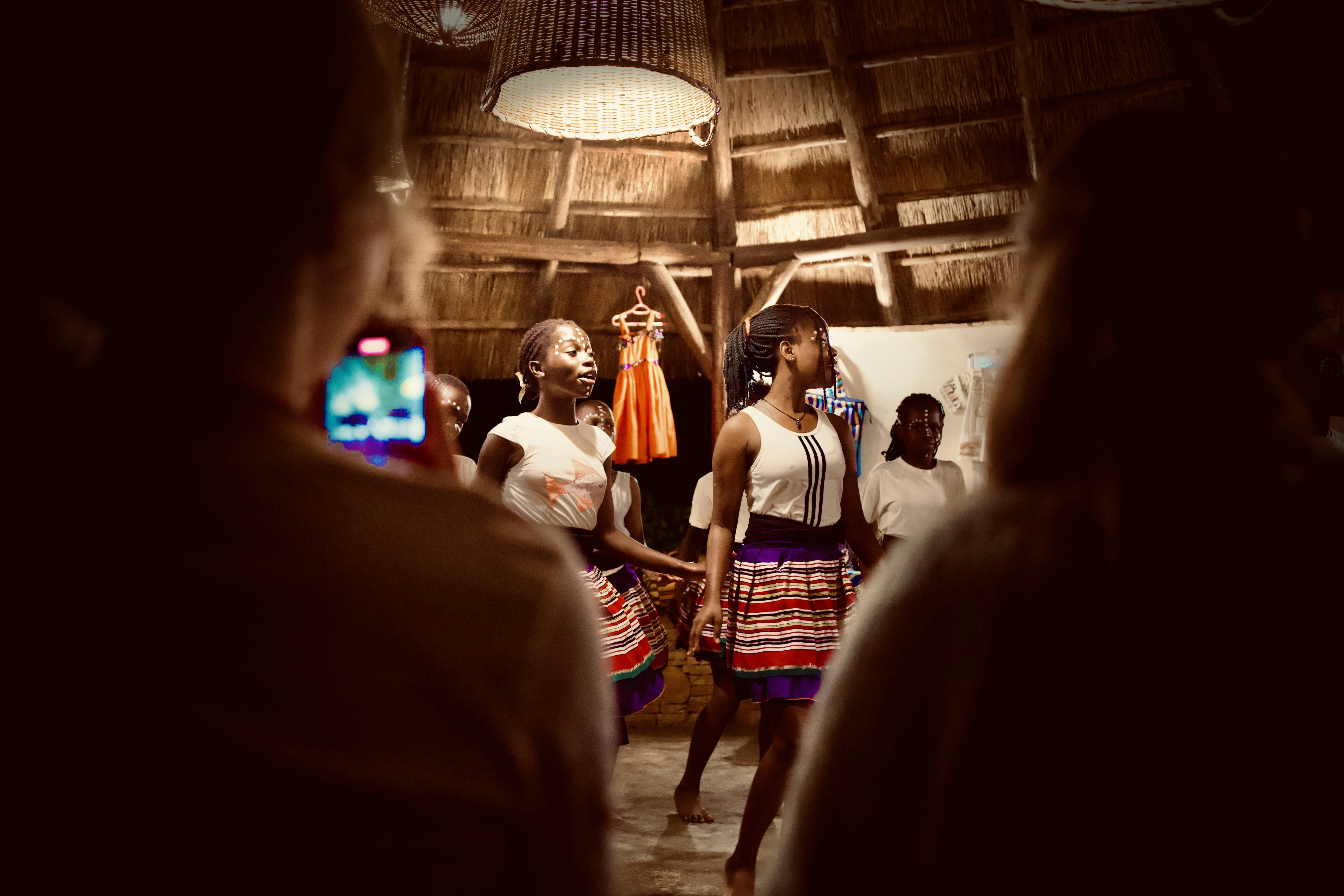 La gente está viendo a los jóvenes bailarines actuar en una habitación.