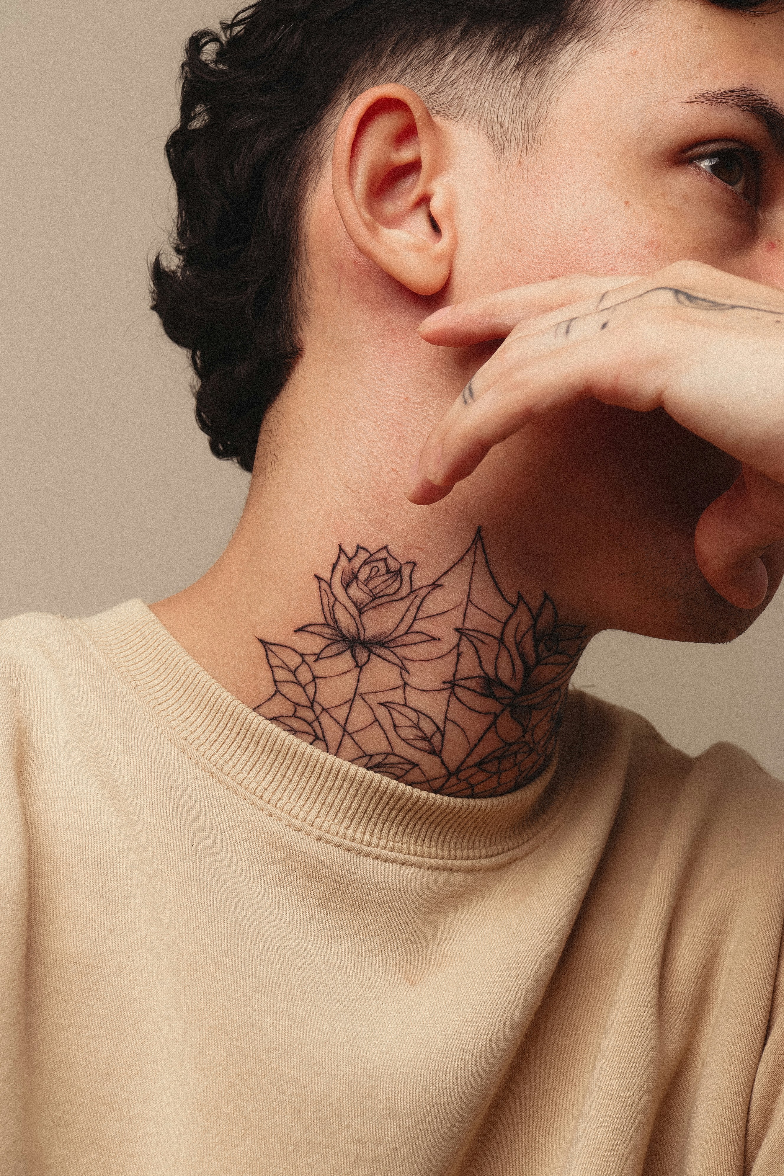 A person displays a neck tattoo and cool mullet.