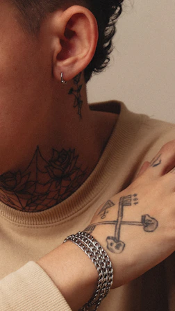 Person with tattoos and a silver bracelet.