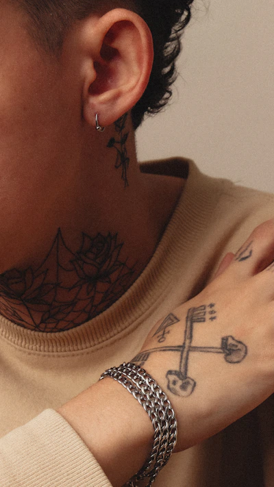 Person with tattoos and a silver bracelet.