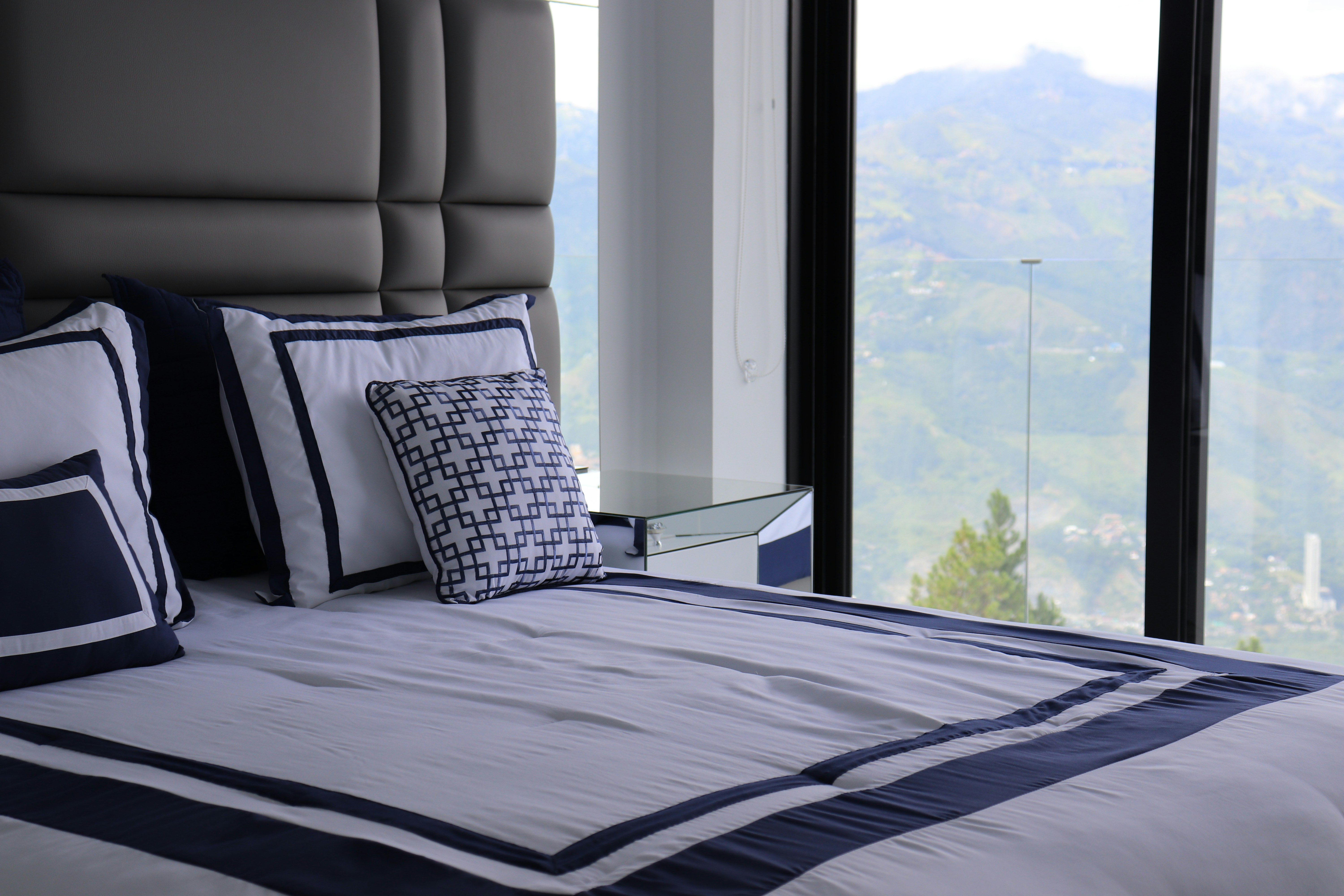 A luxurious bed overlooks a scenic mountain view.