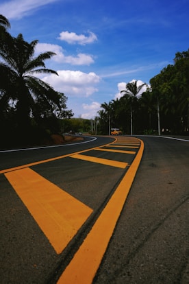 A winding road leads towards the sunny sky.