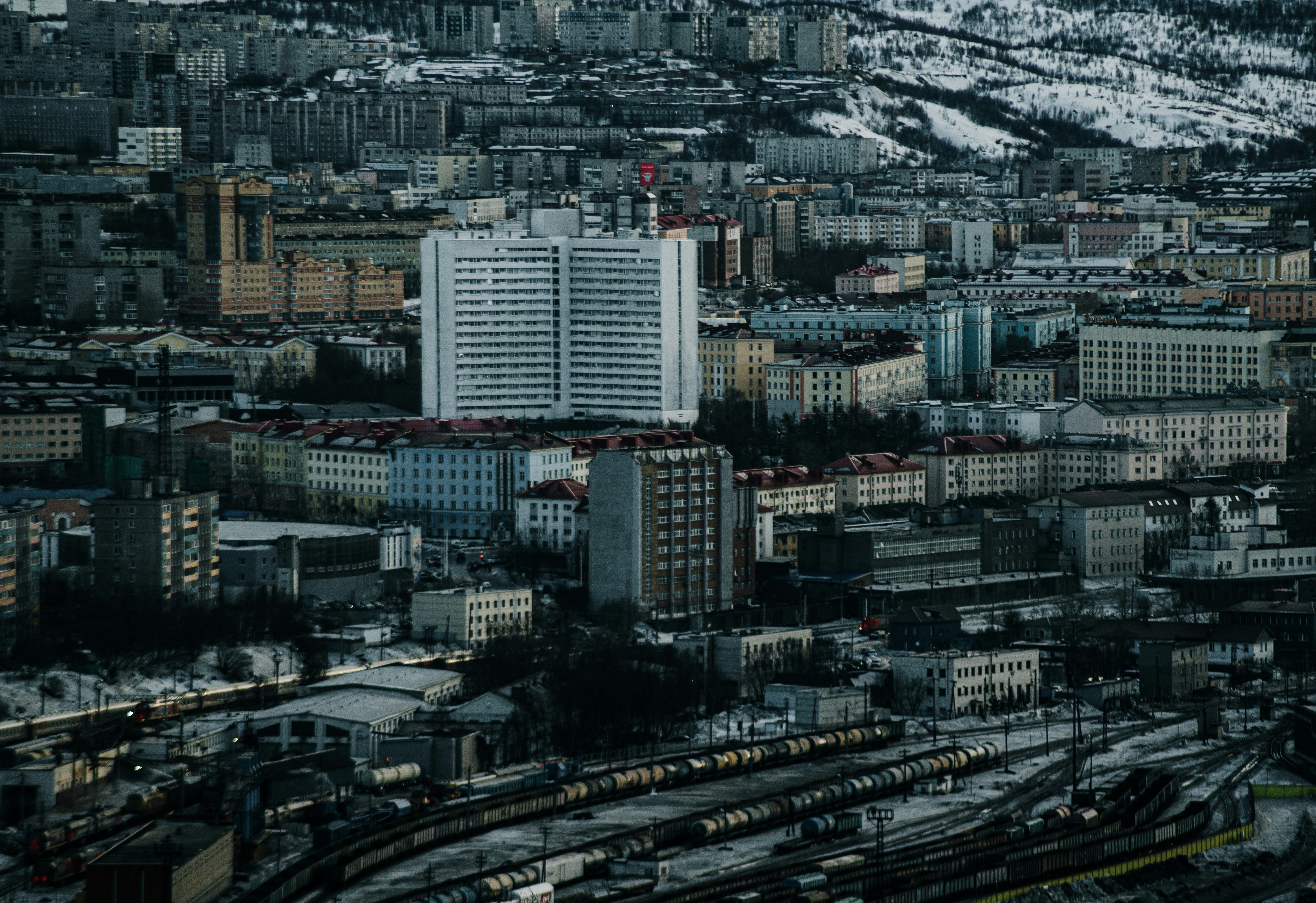 Cityscape of buildings against a snowy backdrop.