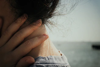 A hand gently cradles a neck.