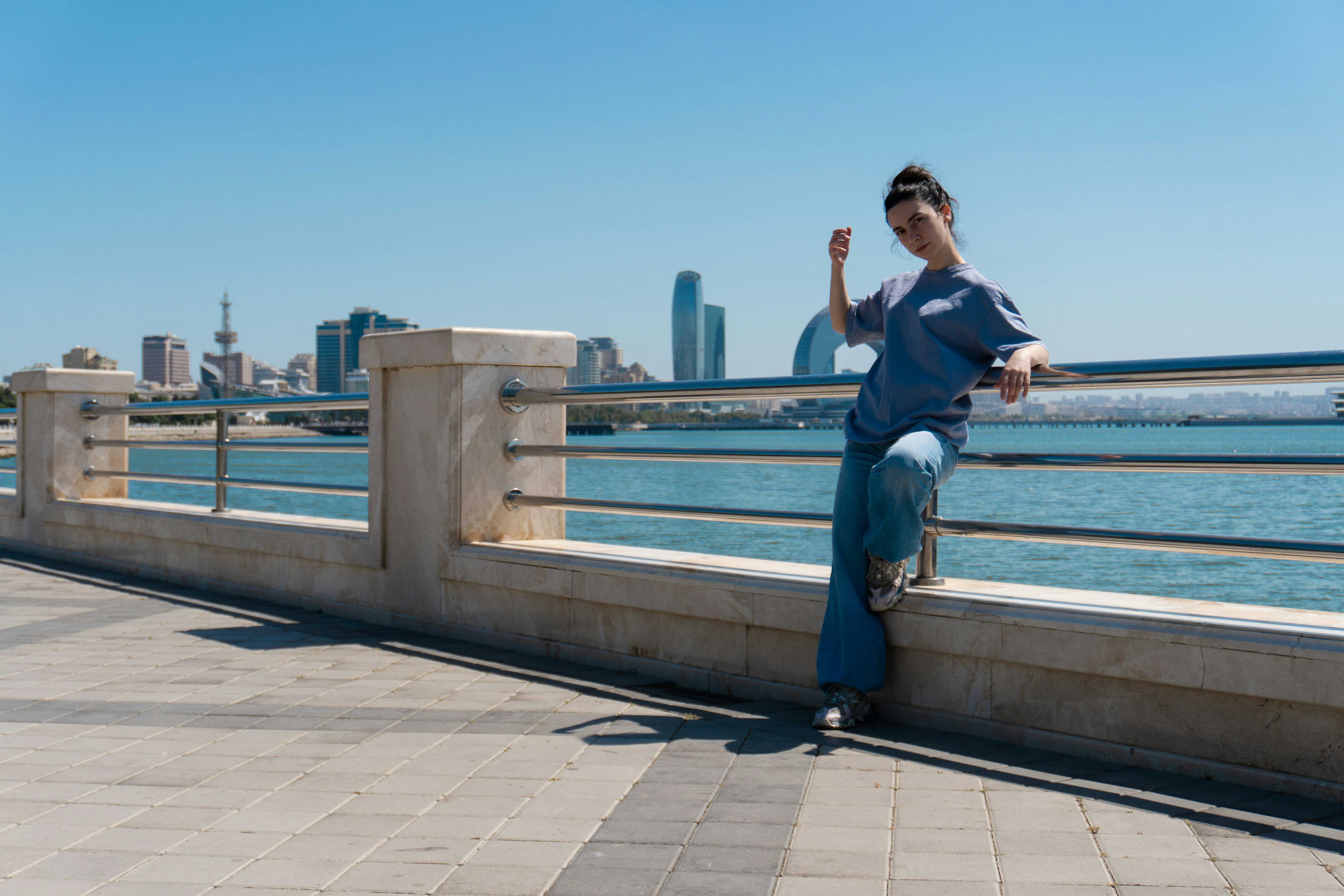A woman poses by the oceanfront.