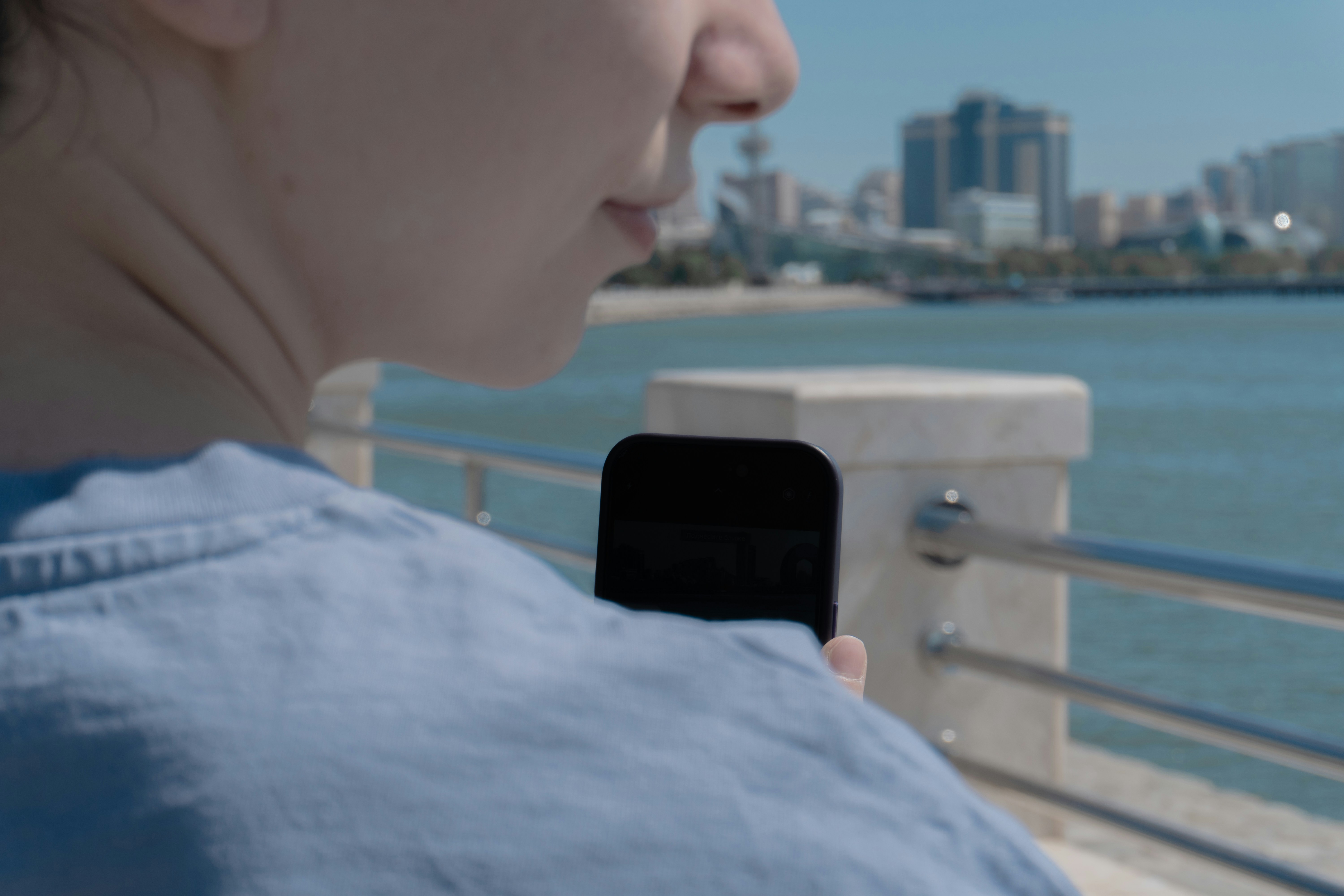 Woman uses her phone with a scenic view.