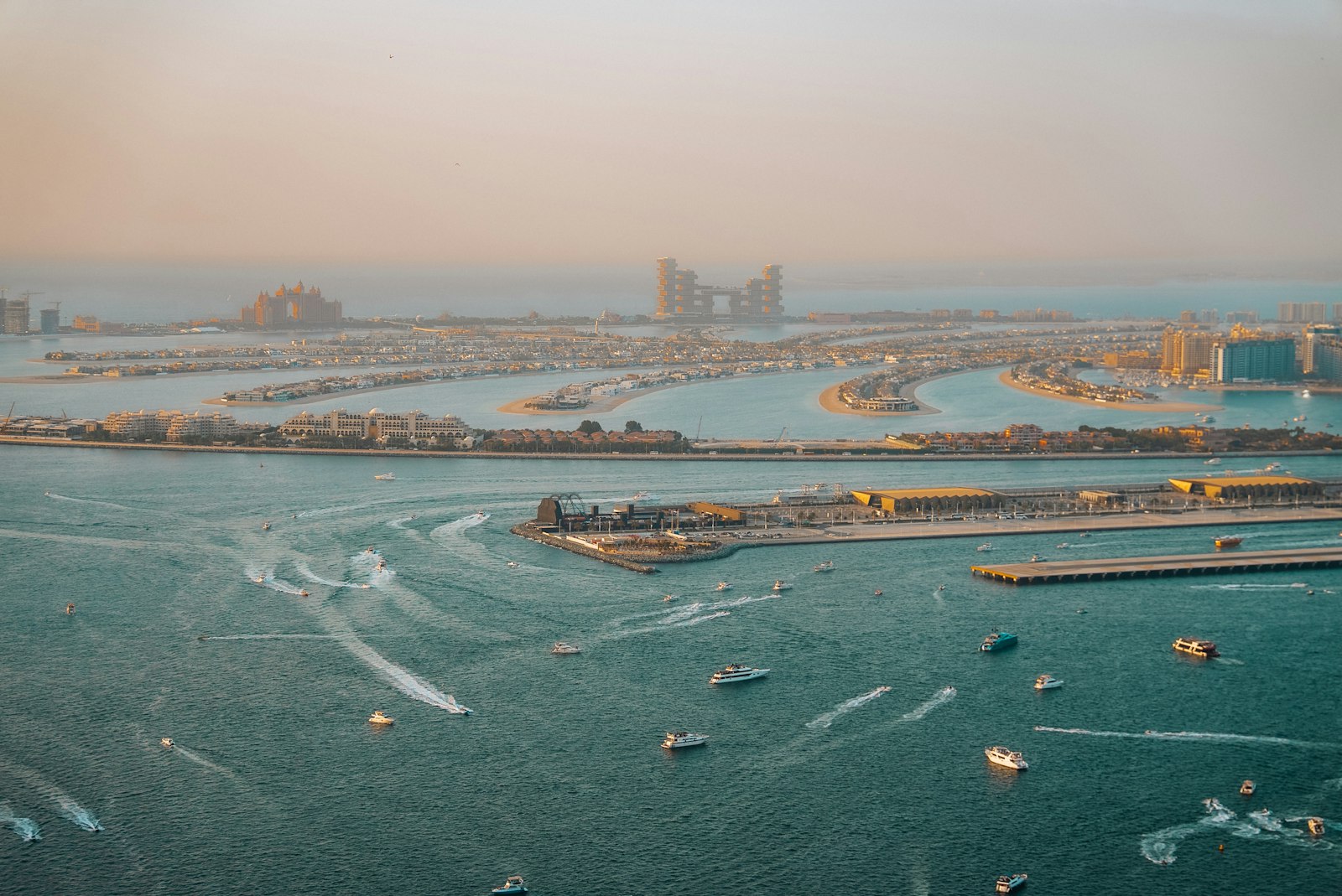 Aerial view of Palm Jumeirah island and Dubai Marina waterfront at sunset