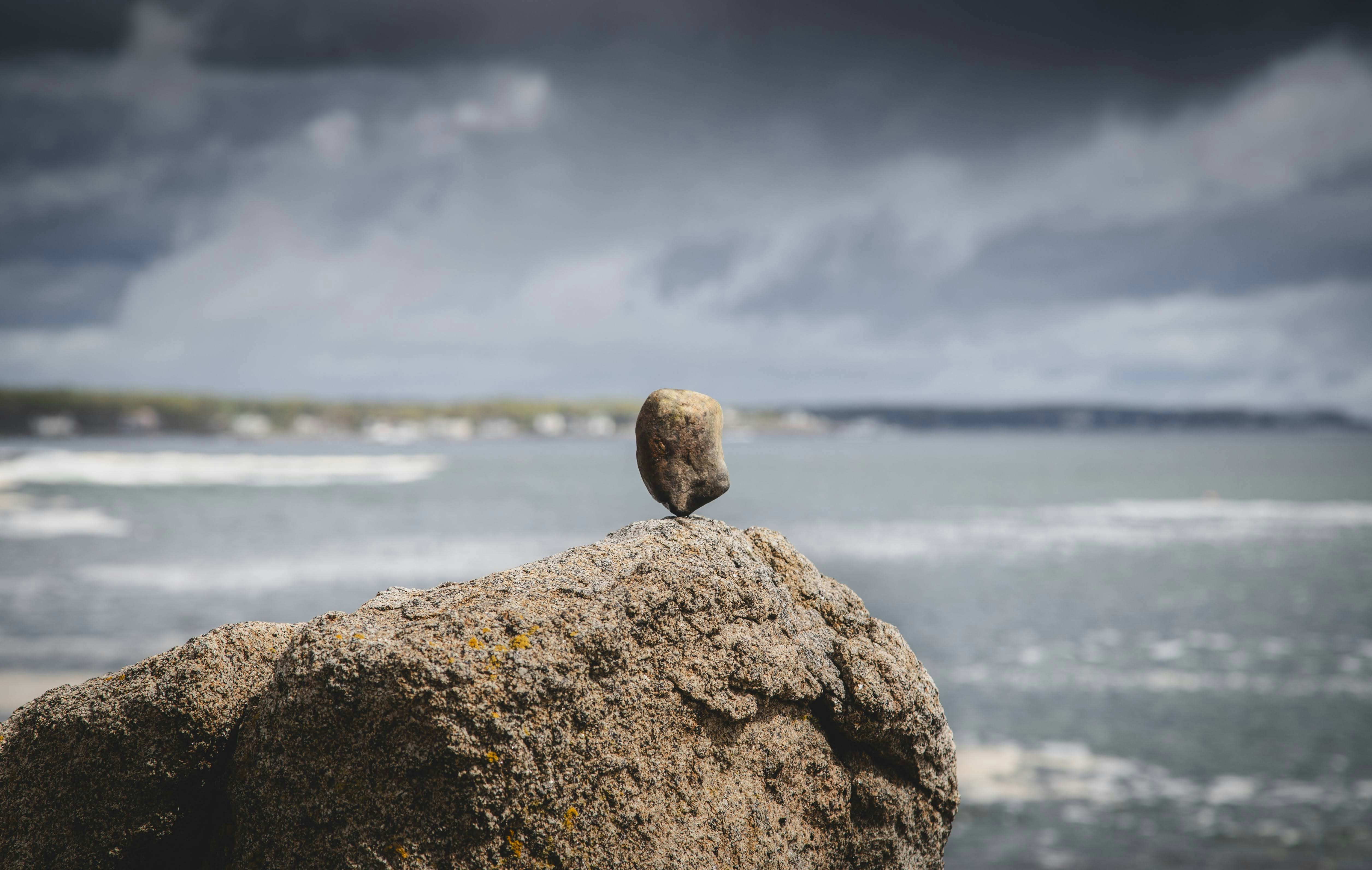 A balanced stone sits upon a rock.