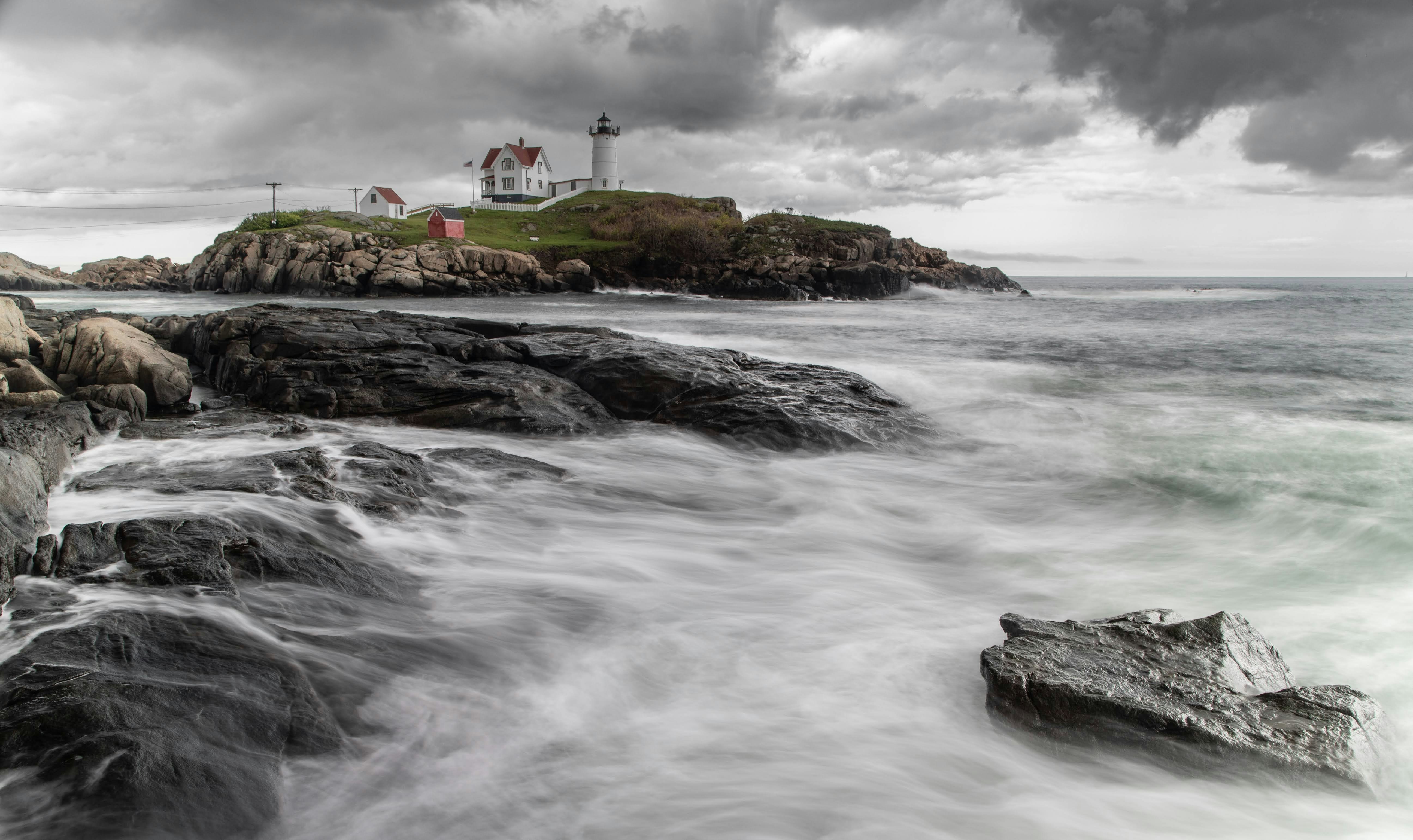 A lighthouse stands guard over a rocky shore.
