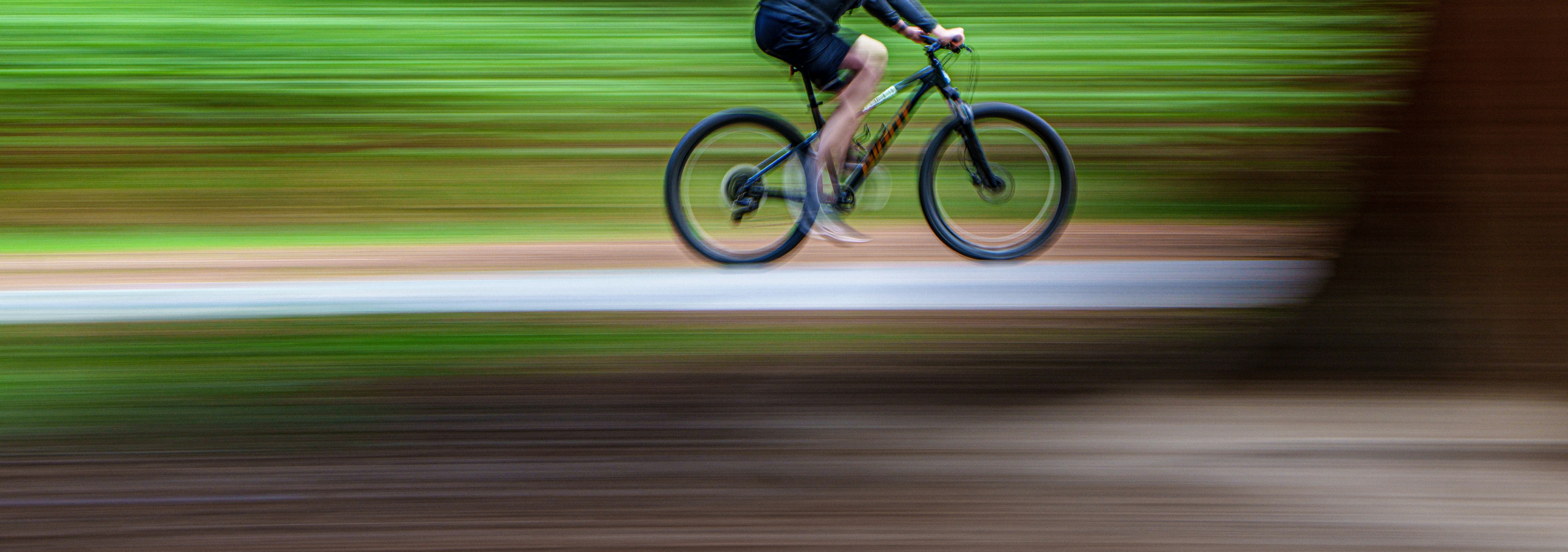 A cyclist is riding a bicycle down a path.