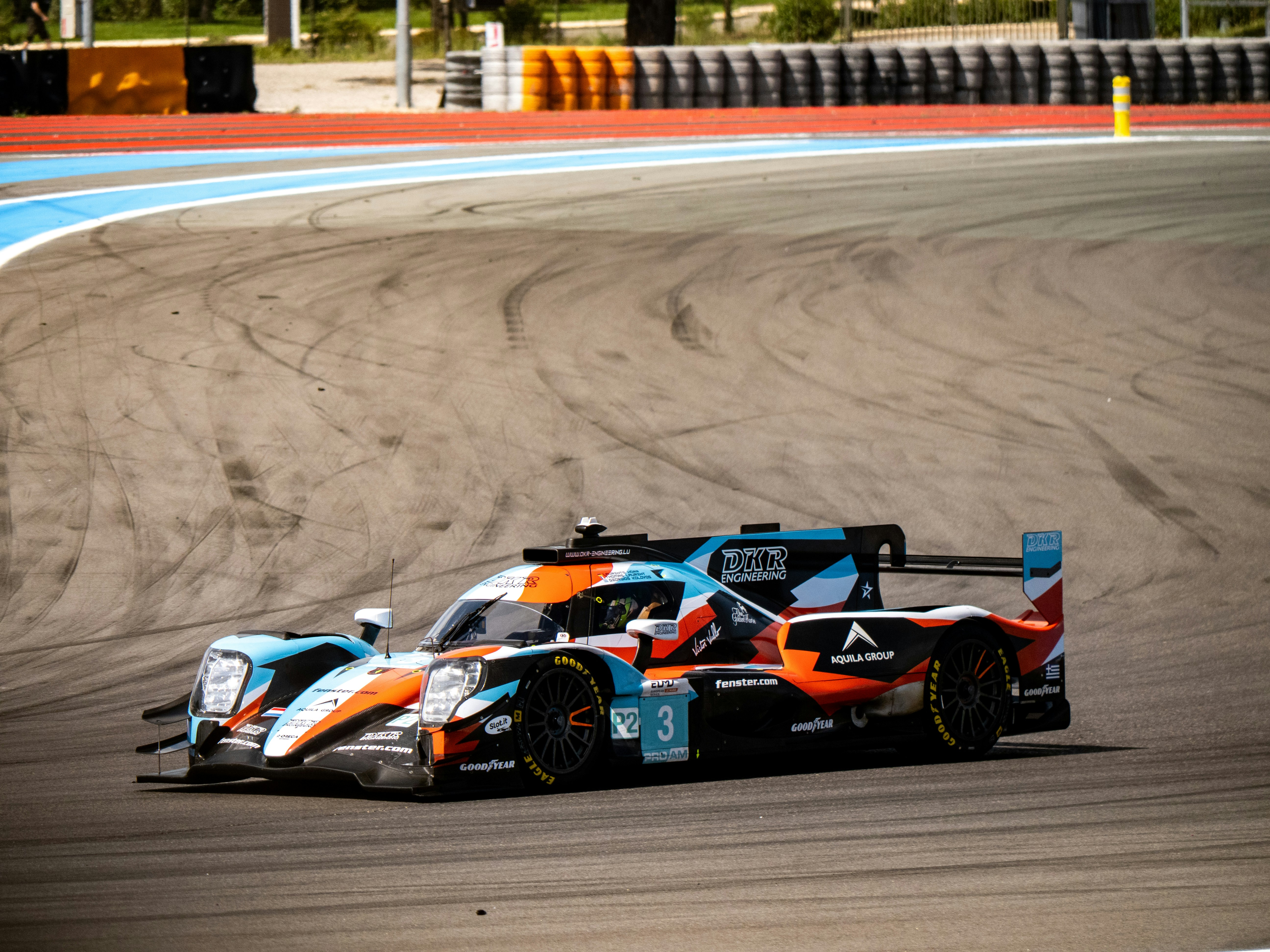Auto da corsa che sfreccia dietro un angolo di pista.