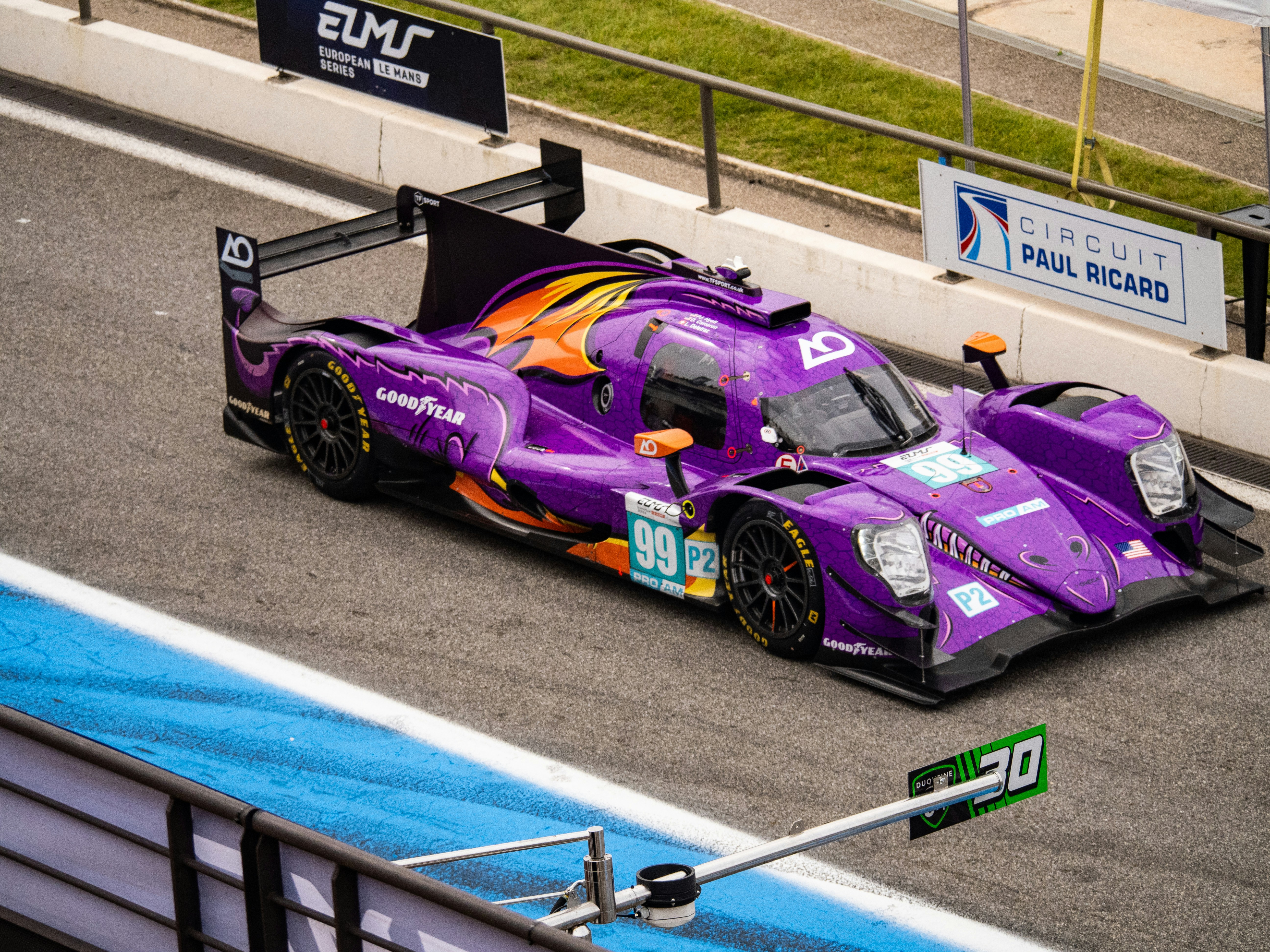 Un'auto da corsa viola sfreccia sulla pista.