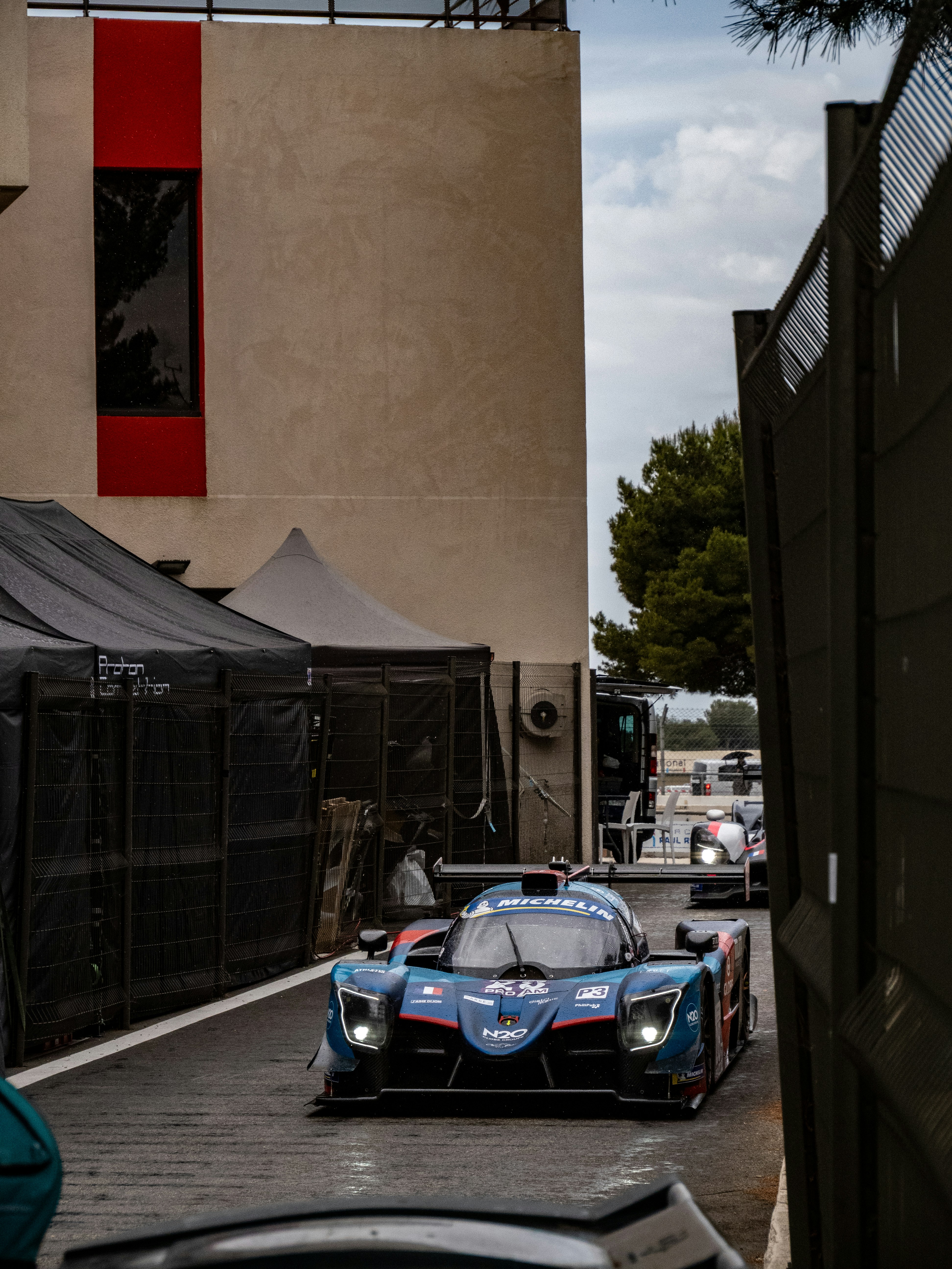 Le auto da corsa stanno guidando lungo la pista.