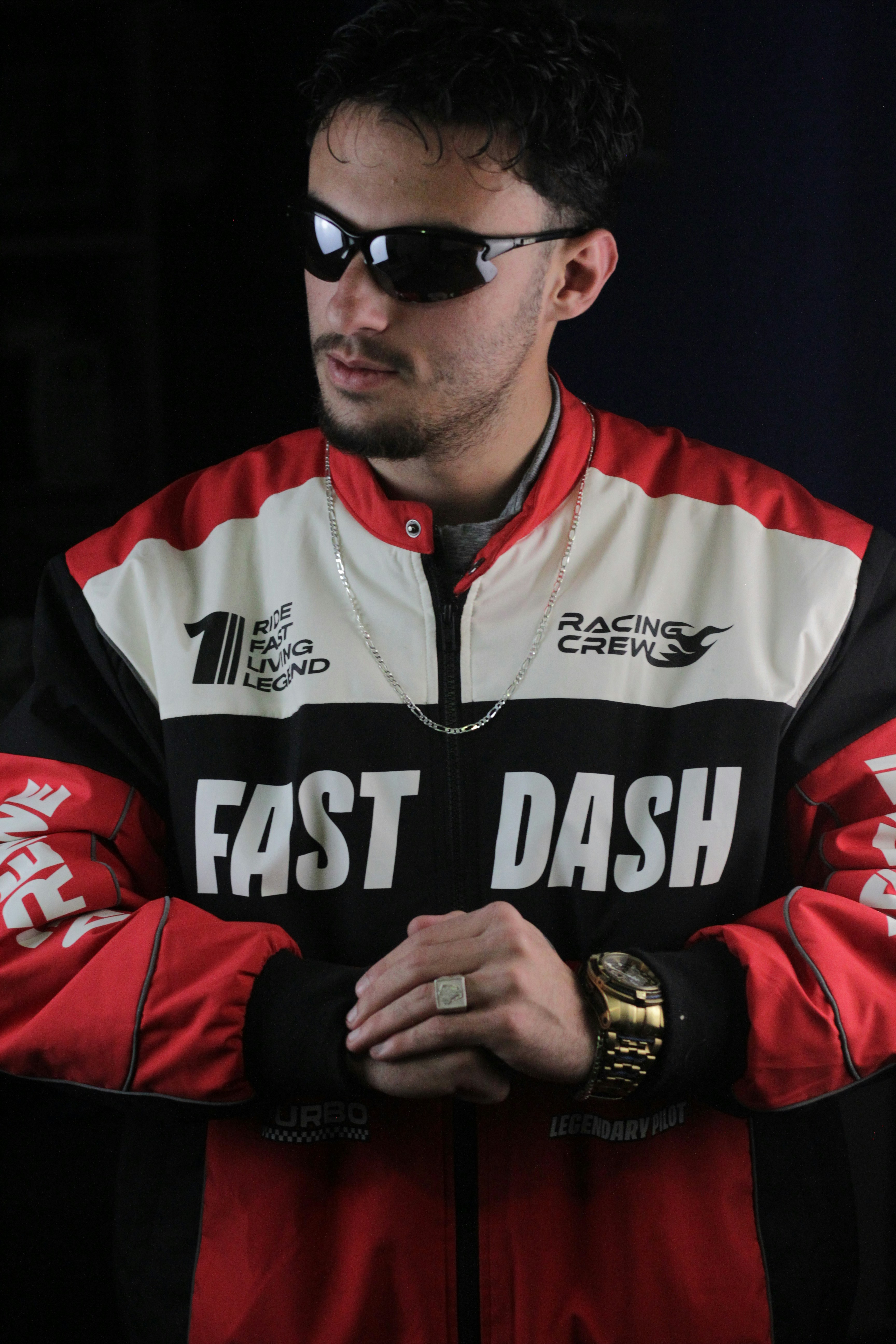 A man in a racing jacket is posing.