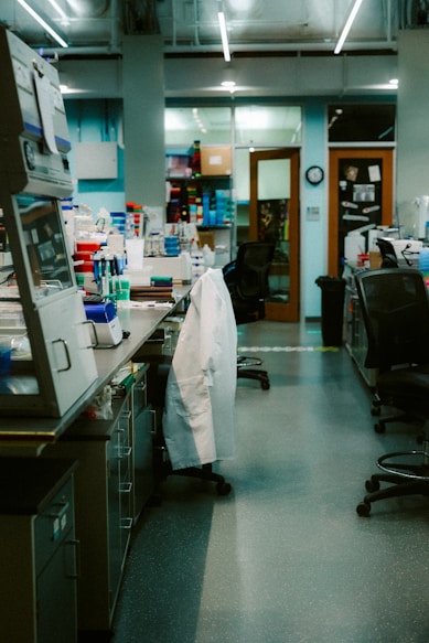 A laboratory is empty with a hanging lab coat.