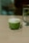 Matcha latte sits on a table next to water.