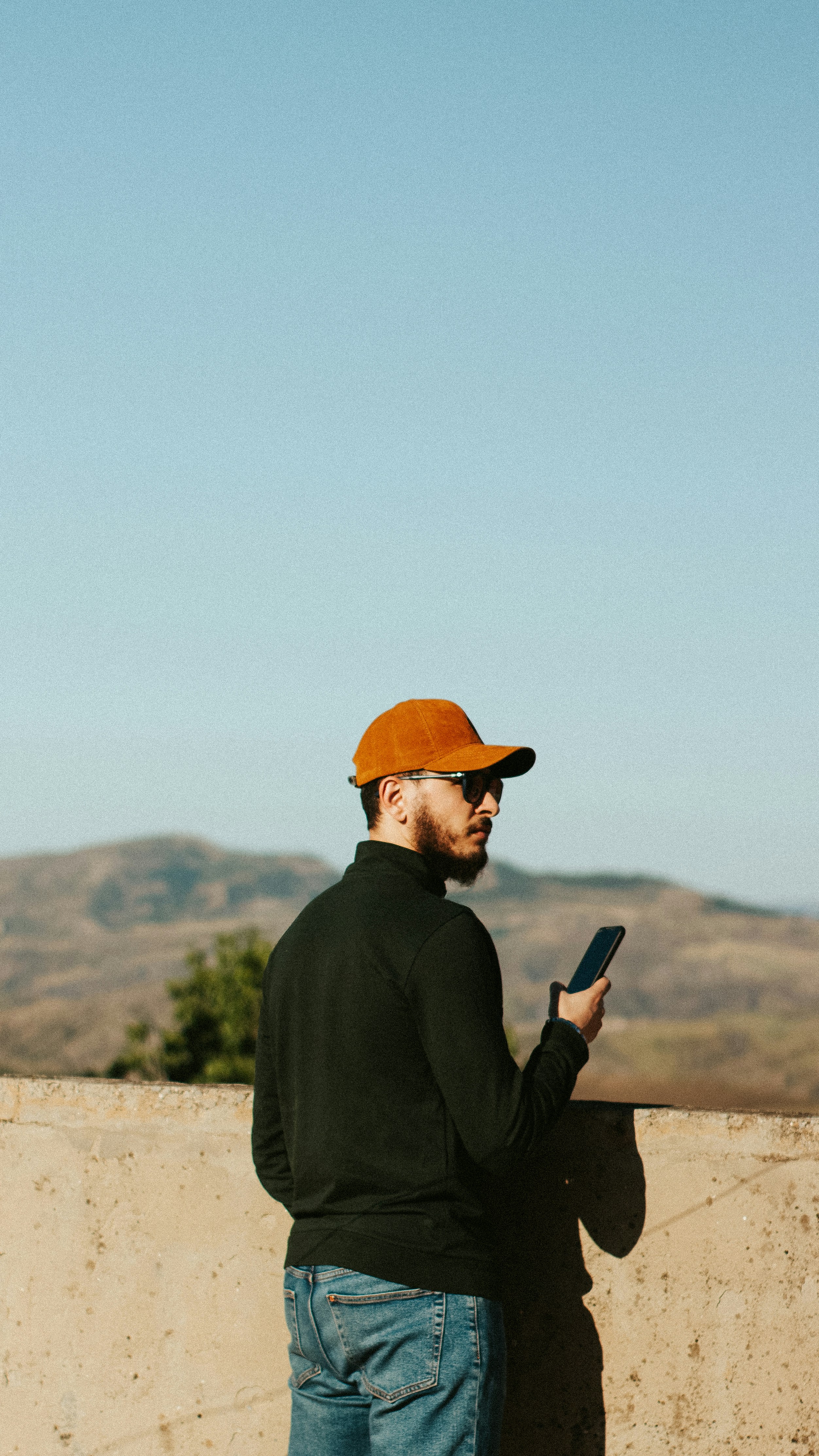 A man uses his phone while looking at the view.