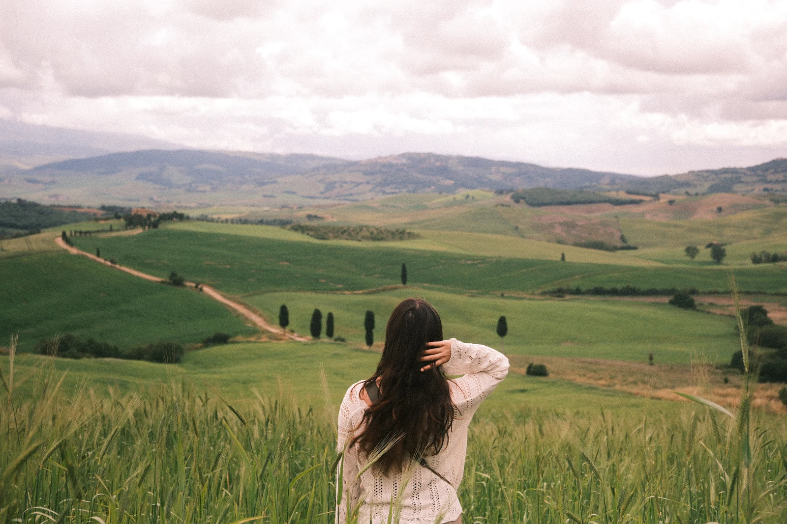 A country road curves through open fields in Val d'Orcia