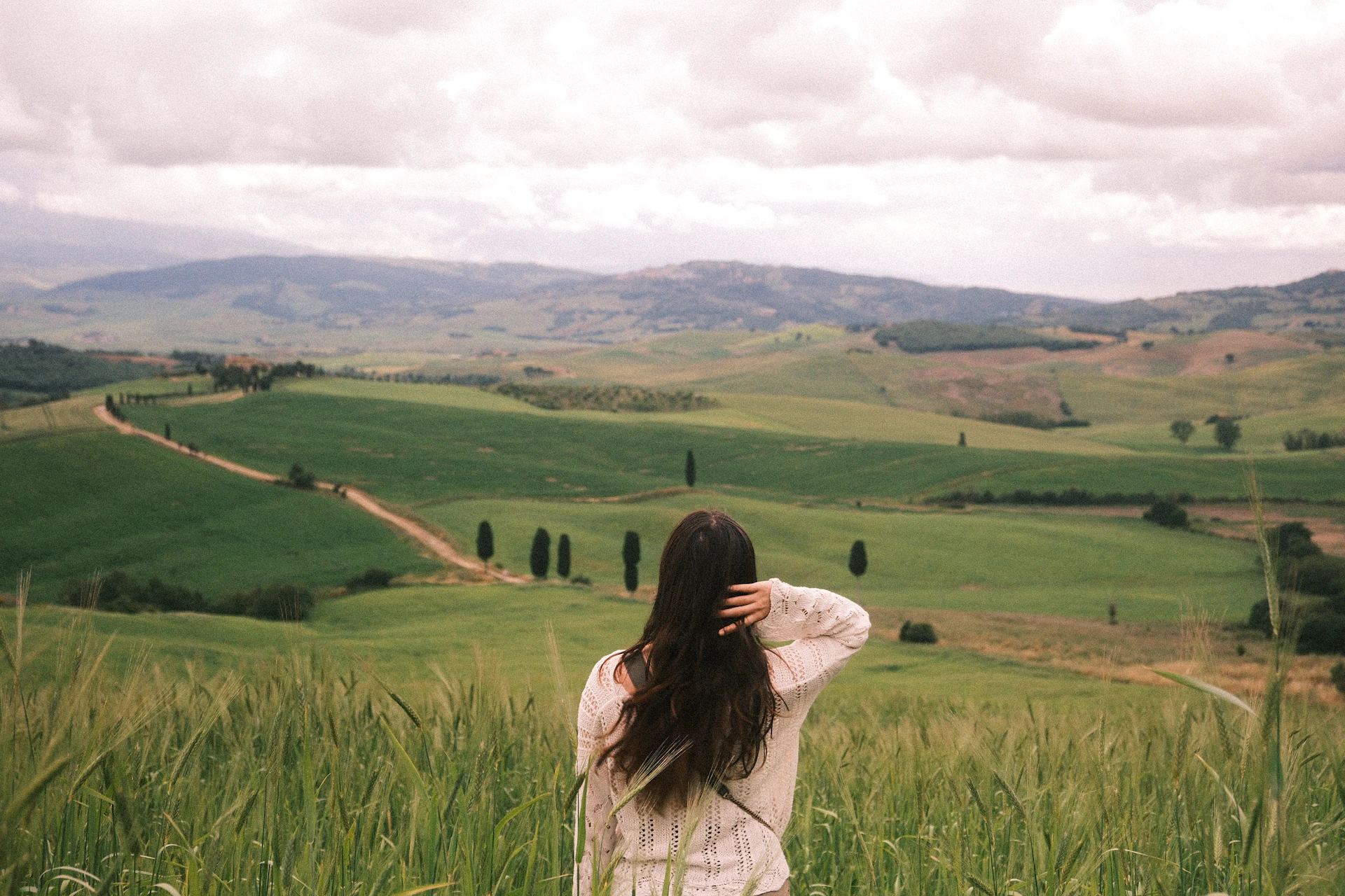 Woman overlooks a beautiful, vast green landscape