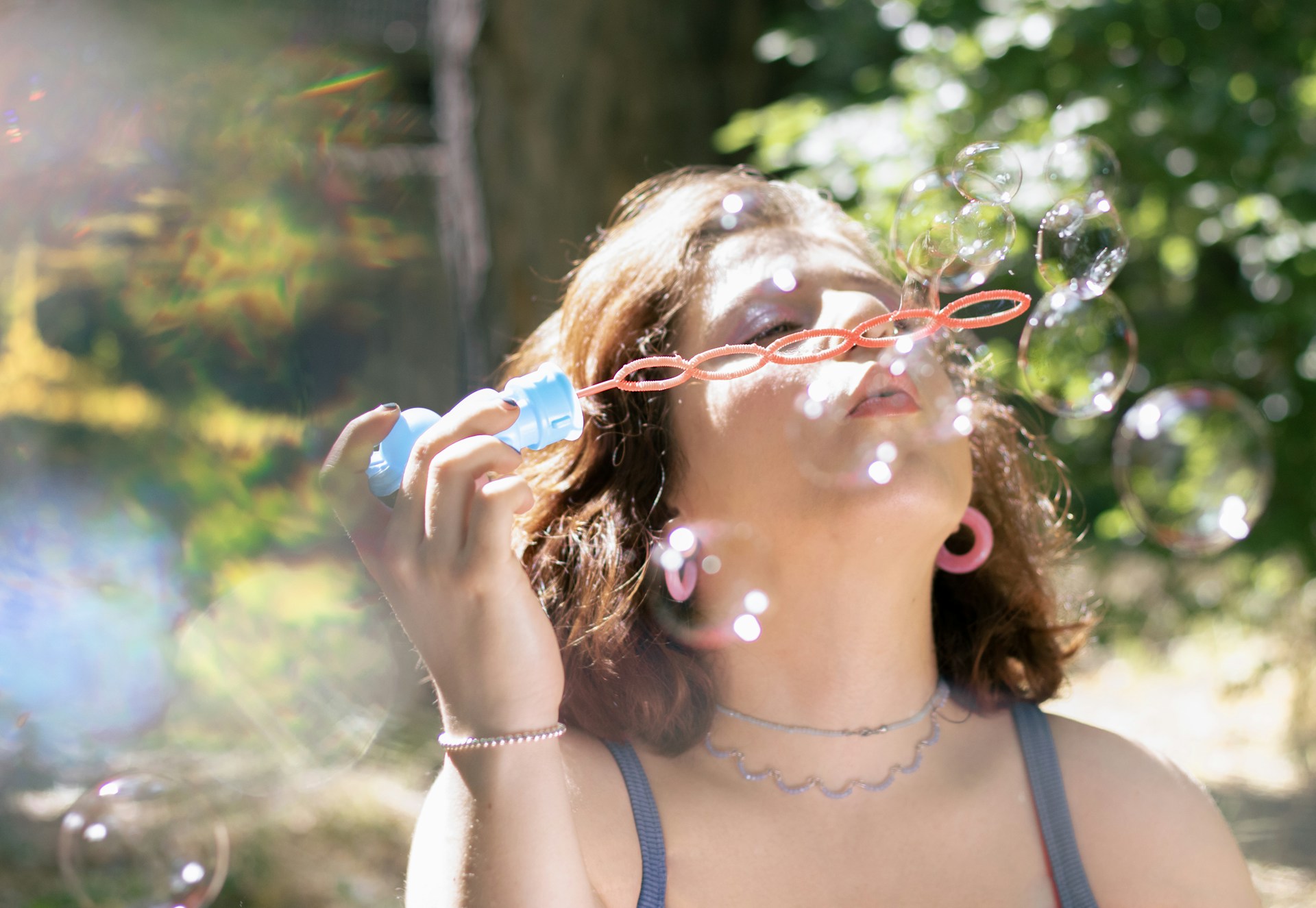 A woman blows bubbles in the sun.