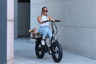 A woman rides an electric bike with flowers.